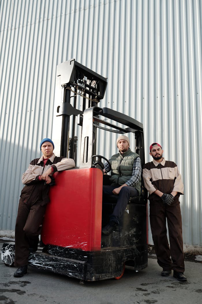 Crafting Captivating Headlines: Your awesome post title goes here Three workers with a forklift at an industrial location, exemplifying teamwork and heavy equipment operation.